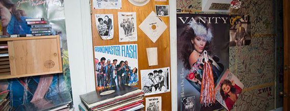 A wall of DJ Michael Webster's home with albums and posters