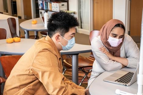 Peer consultant Raneem Rizvi, right, works with Shanlong Yu, a fifth-year Mechanical Engineering student from China, on a paper he is writing on Oct. 25, 2021 in the Naugle Comm Lab.