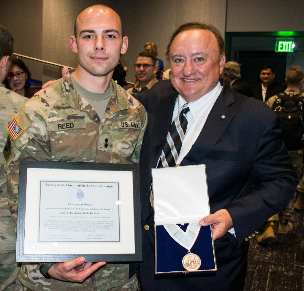 Two men holding awards