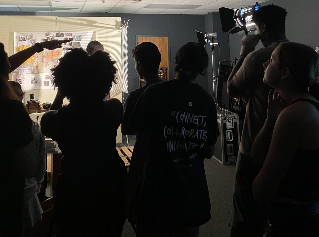 Silhouetted students working on a film set