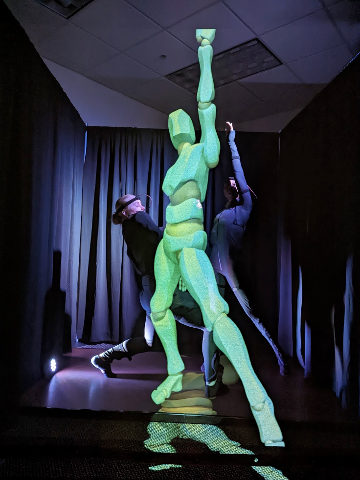 Students dancing in the LuminAI project with a green robot following along