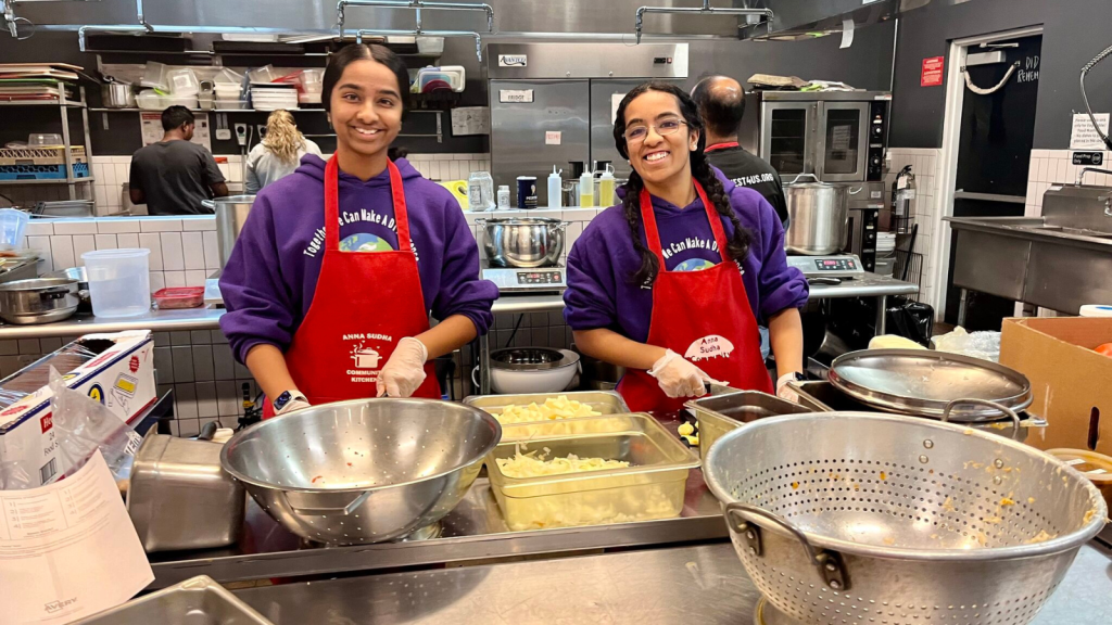 Esha and her sister serving food at a soup kitchen