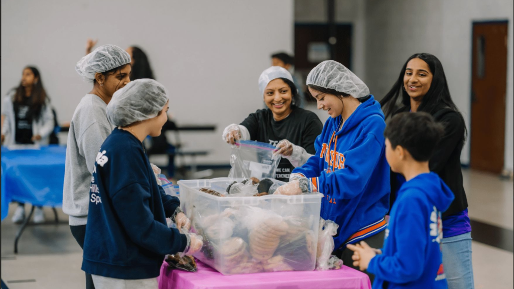 Esha packing food at a volunteer event 