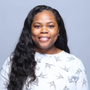 Driani Gambrell poses against a light blue background.