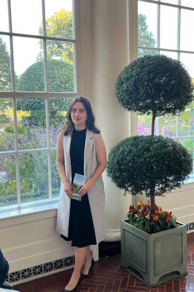 A visitor to Washington, DC poses beside a potted tree inside the White House