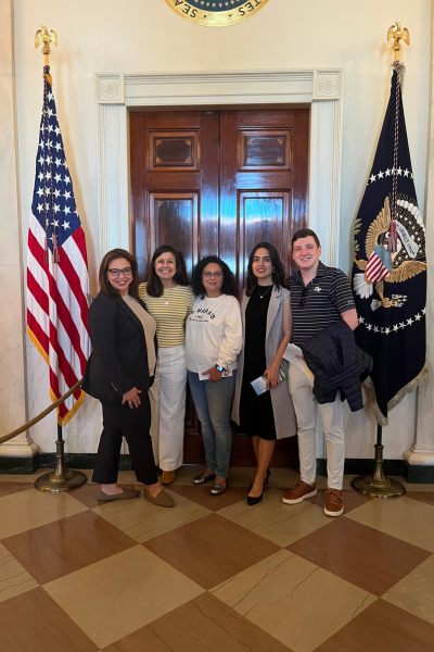 Visitors to Washington stand together in front of the door to the Oval Office