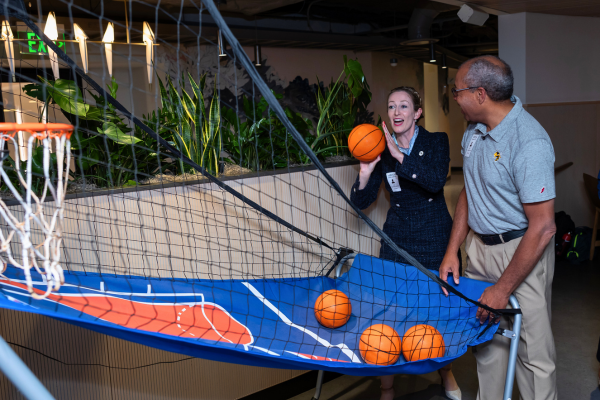 Cassidy Sugimoto gets ready to shoot a basketball into an arcade game hoop.