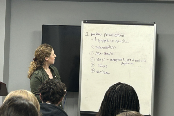 An instructor presents to the class with writing on a flip chart.