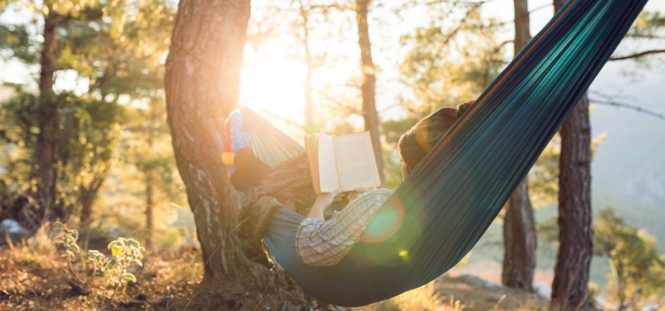 Person in hammock reading a book.