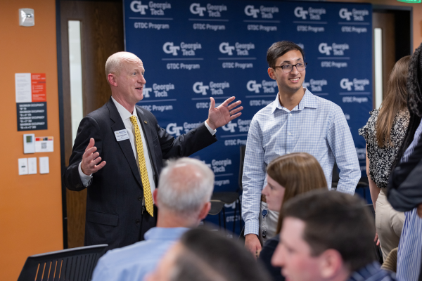 Dene Sheheane gestures while speaking with a student in the audience.