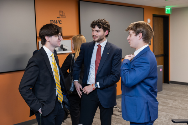 A group of students socialize after the panel discussion.