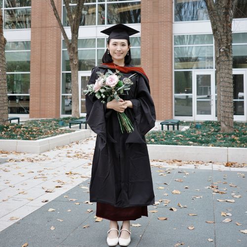 Lai's grad photo in cap and gown with flowers