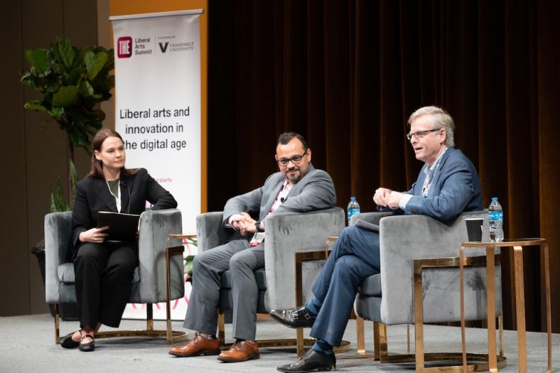 Interim Dean Richard Utz onstage at the Liberal Arts Symposium. A banner in the background reads "Liberal arts and innovation in the digital age."