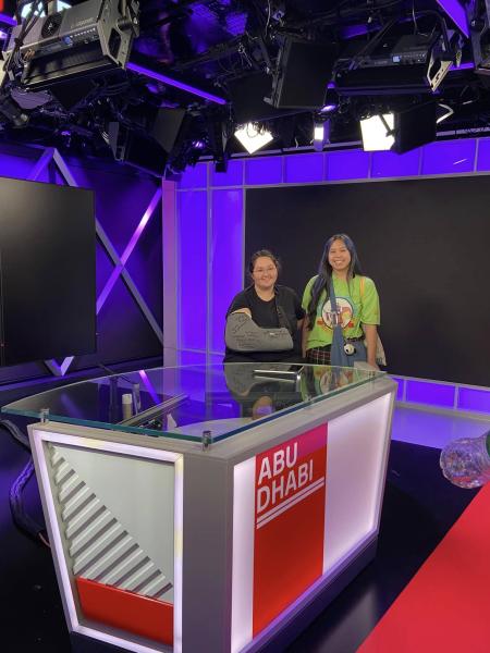 two students at a CNN desk/newsroom