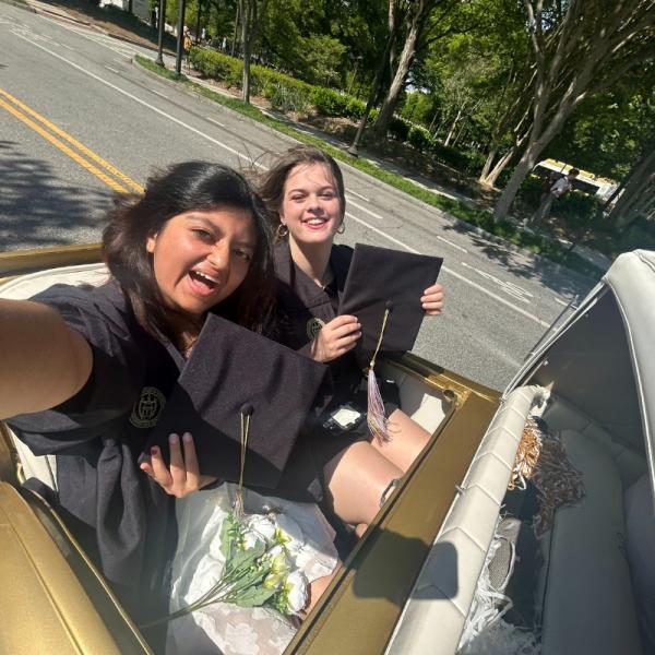 Franks and a friend riding in the Wreck in their graduation gowns