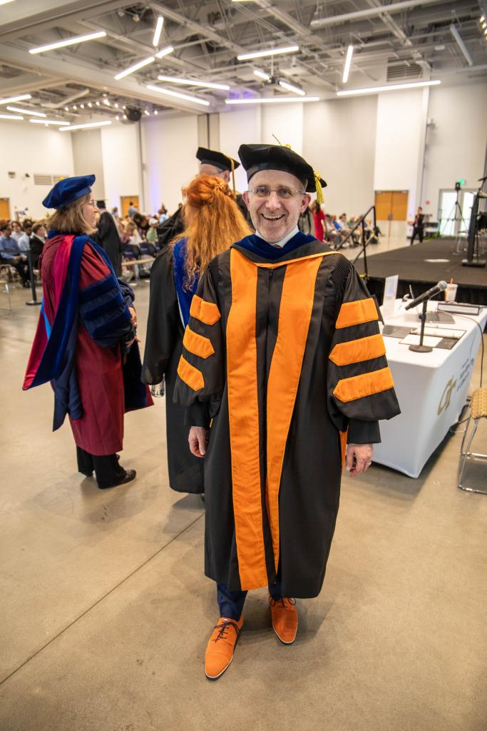 faculty member in robes and orange shoes