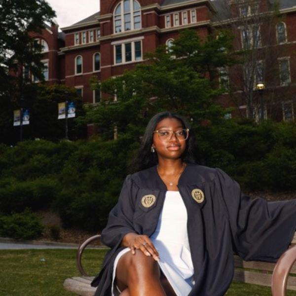 Iyabar in grad gown in front of tech tower