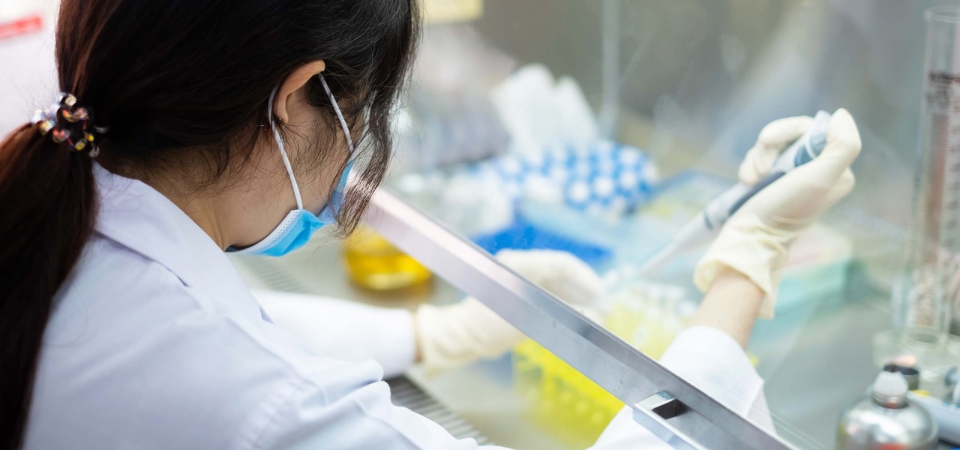 Person in lab coat using equipment.