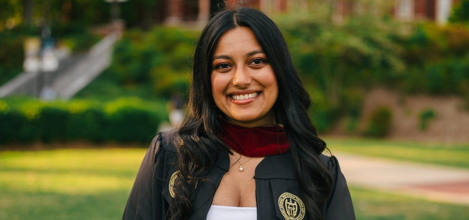 Simran Patel stands in her graduation gown in the Tech Tower courtyard.