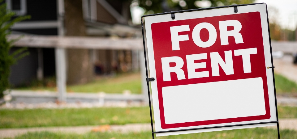 For rent sign in the yard in front of a house 