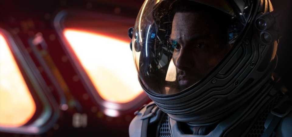 An astronaut in a spacesuit inside a spaceship.