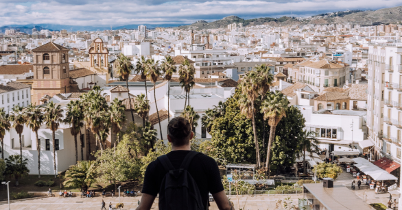 Man looks out over a view of a European city