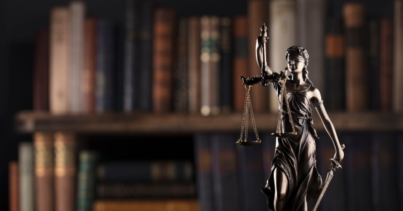 stock image of law books and a justice statue