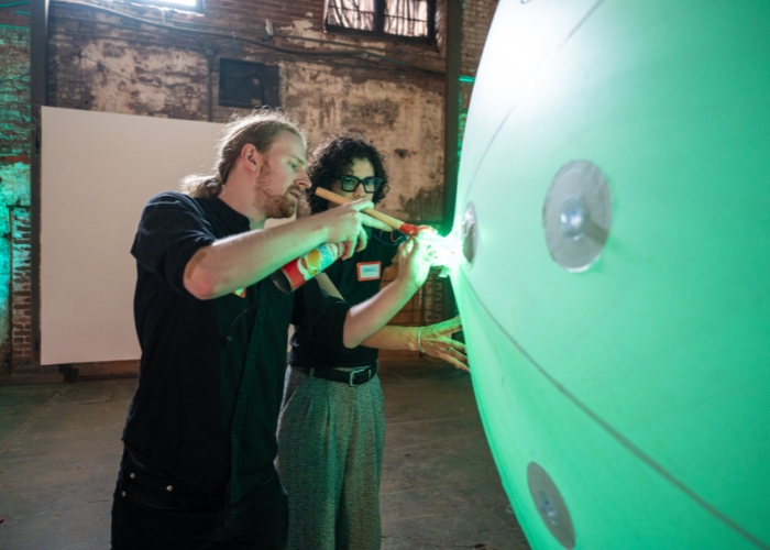 Brian Magerko stands with a graduate student working on a piece in his “Sound Clouds” interactive installation at Atlanta's Goat Farm Cultural Center.