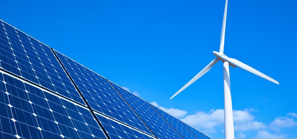 Solar panel with wind mill in the background.