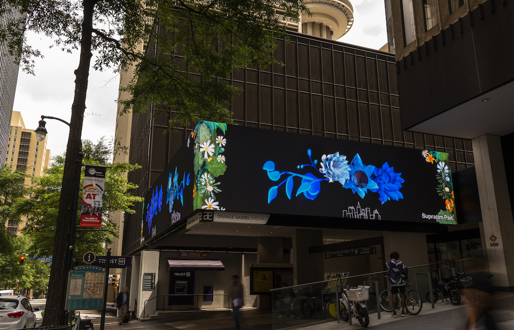 a digital billboard on a building showing digitally rendered flowers