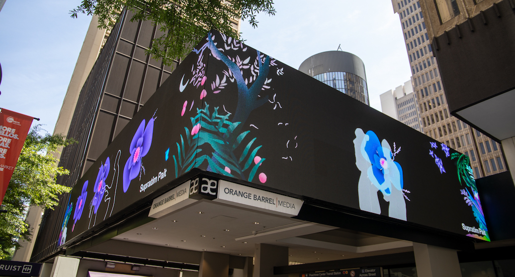 a digital billboard showing flowers, greenery, and a couple dancing