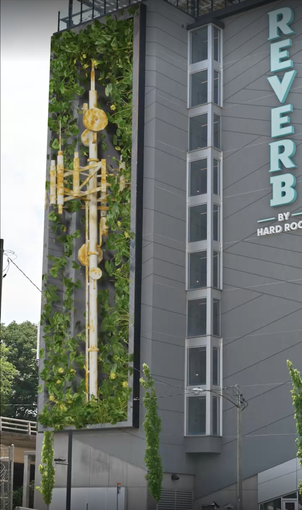 a digital billboard on a building showing a cell tower covered in lush green foliage