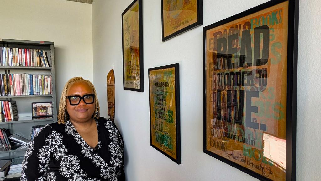 Susana Morris in her office near posters that bear messages such as, "Read in Order to Live