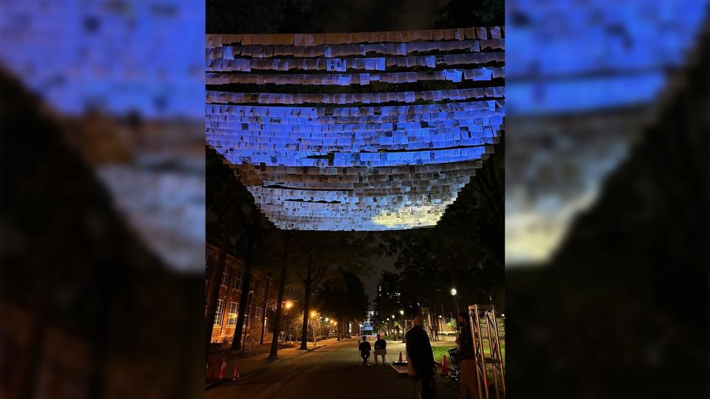 Blue-tinted papers hang above a street at night.