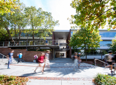Blurred students walking in front of the Skiles Building at Georgia Tech, home to the School of LMC.