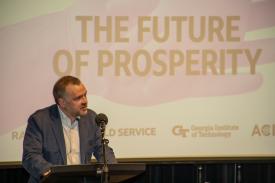 Reith Lecturer Ben Ansell at the podium with "The Future of Prosperity" on the screen behind him