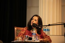 Anita Anand seated at a microphone