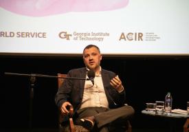 Ben Ansell seated onstage at a microphone